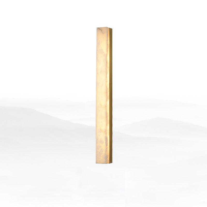 Tallest Kristy alabaster wall lamp in brass, lit, showing its narrow rectangular profile.