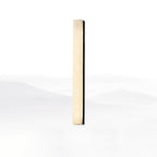 Tall black-framed Kristy alabaster wall lamp, lit, seen from a shallow angle on white.
