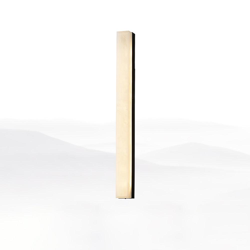 Tall black-framed Kristy alabaster wall lamp, lit, seen from a shallow angle on white.