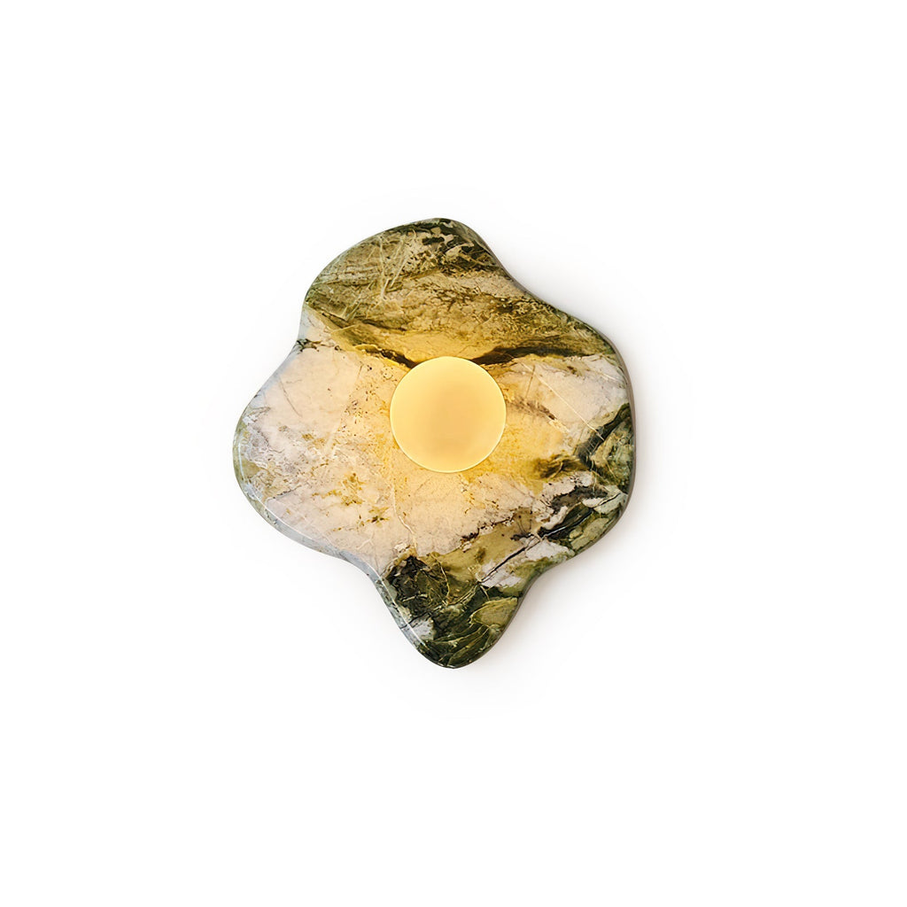 Fully lit, this Clérachic wall light's freeform green-and-white marble glows warm against a plain beige wall, tightly cropped.