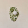 Another angular marble cut of this Clérachic wall light, photographed straight-on with the glass globe set off-centre.