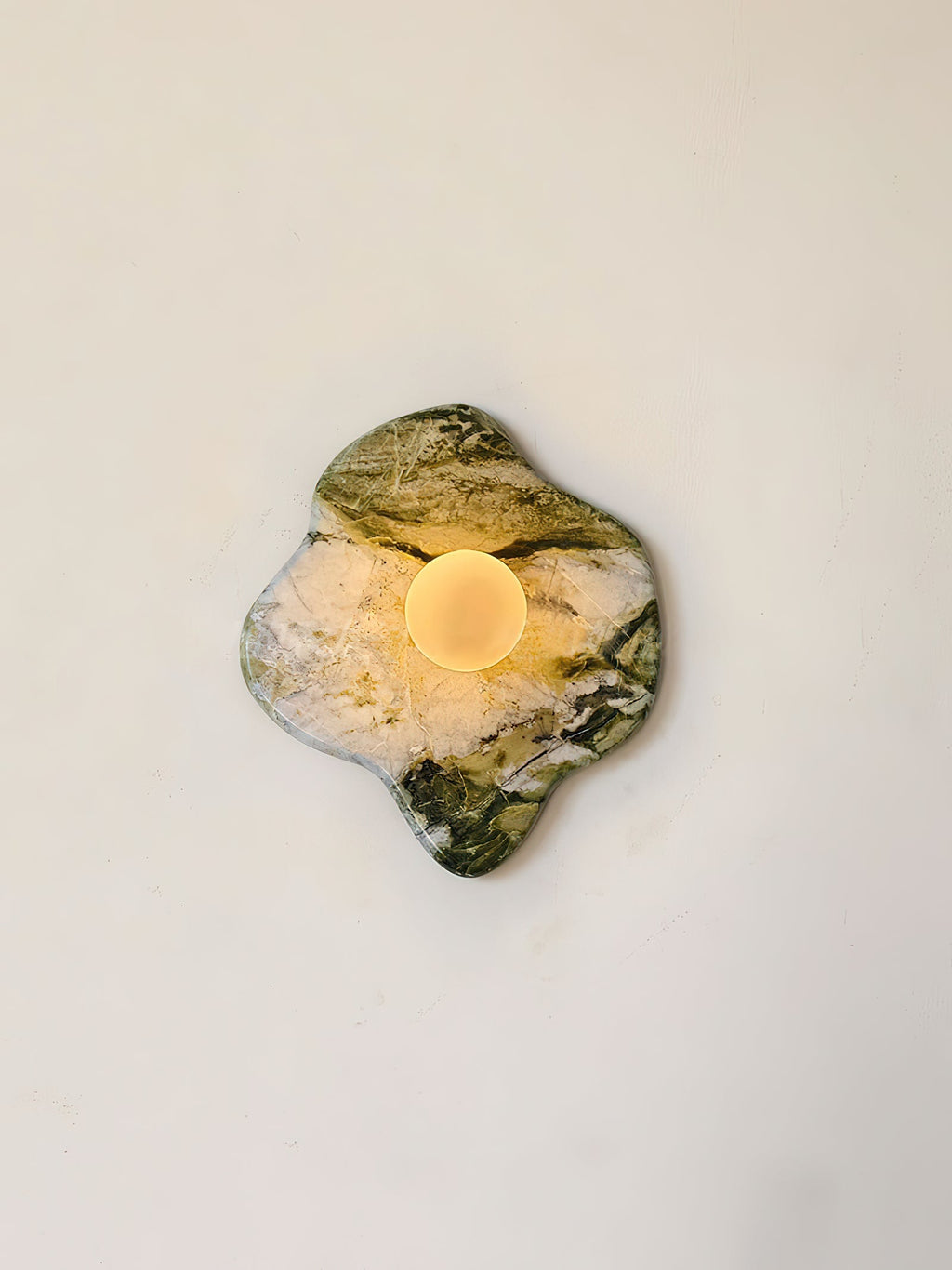 Glowing warm within a narrow crop, this Clérachic wall light's puddle-shaped marble shows deep green striations across its face.