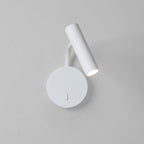 A white Clérachic wall sconce with its arm curved down, lit against a plain grey backdrop.