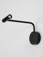On a plain grey background, this black Clérachic wall sconce has its head angled forward.