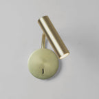 A gold Clérachic wall sconce with its head angled forward, photographed on a plain backdrop.