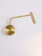 A gold Clérachic wall sconce with its arm bent low, photographed against an off-white backdrop.