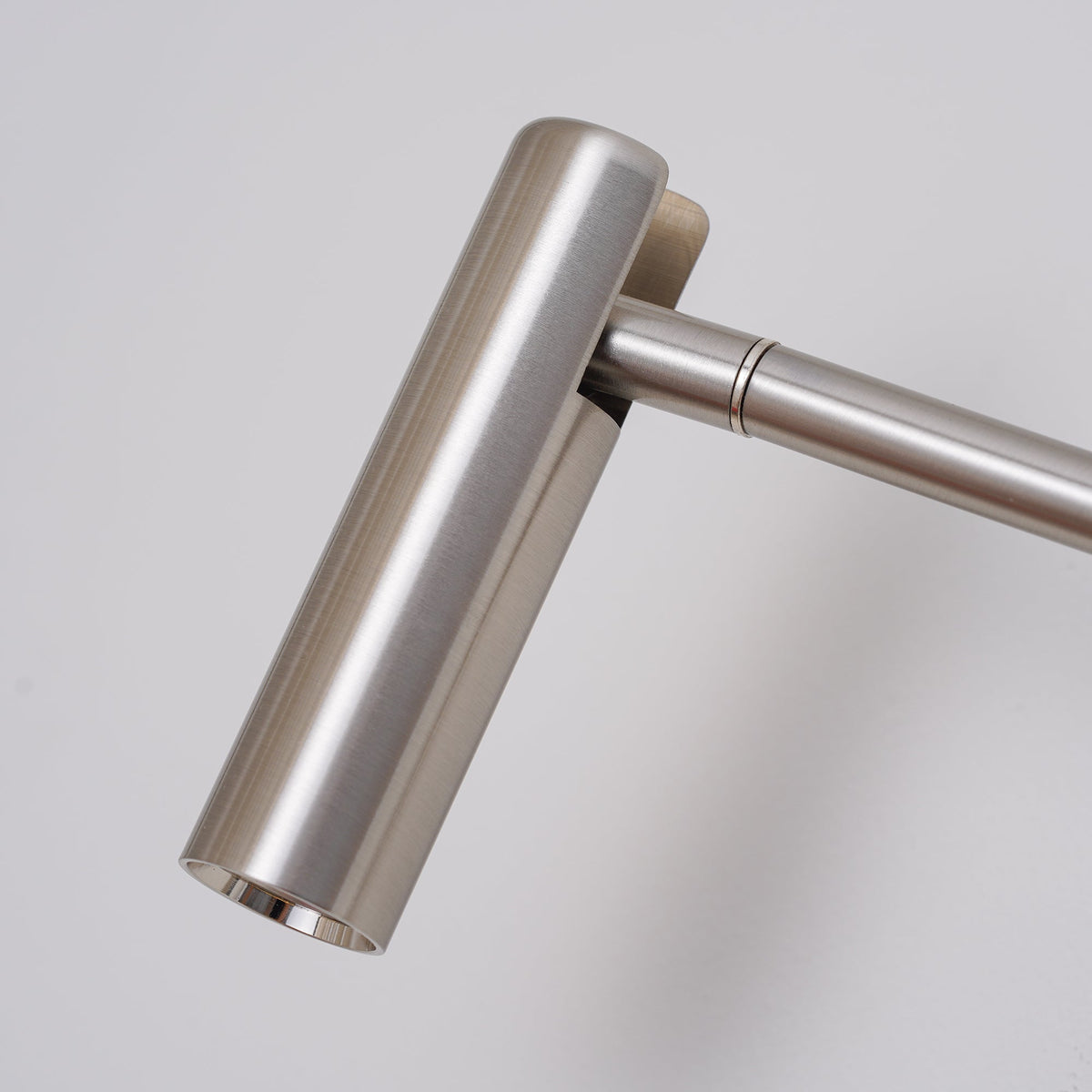 Close-up of the pivoting joint on this Clérachic wall sconce, in a brushed sand nickel finish.