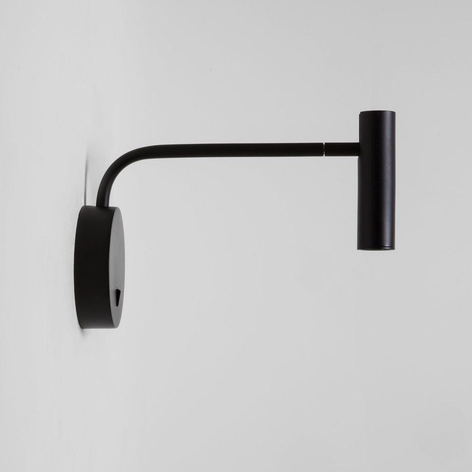 Close view of the base plate and switch on this black Clérachic wall sconce, arm extended sideways.