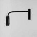 Close view of the base plate and switch on this black Clérachic wall sconce, arm extended sideways.