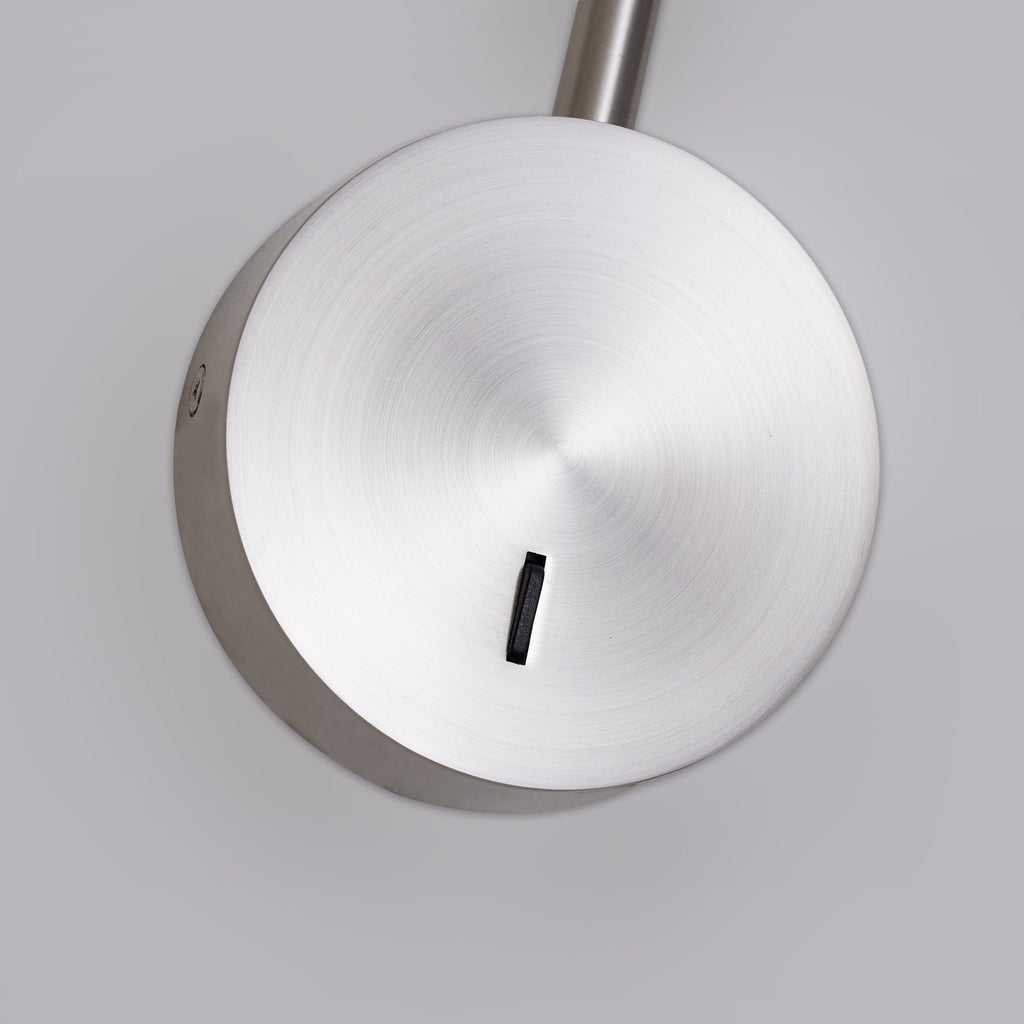 Close view of the brushed sand nickel disc base and switch on this Clérachic wall sconce.