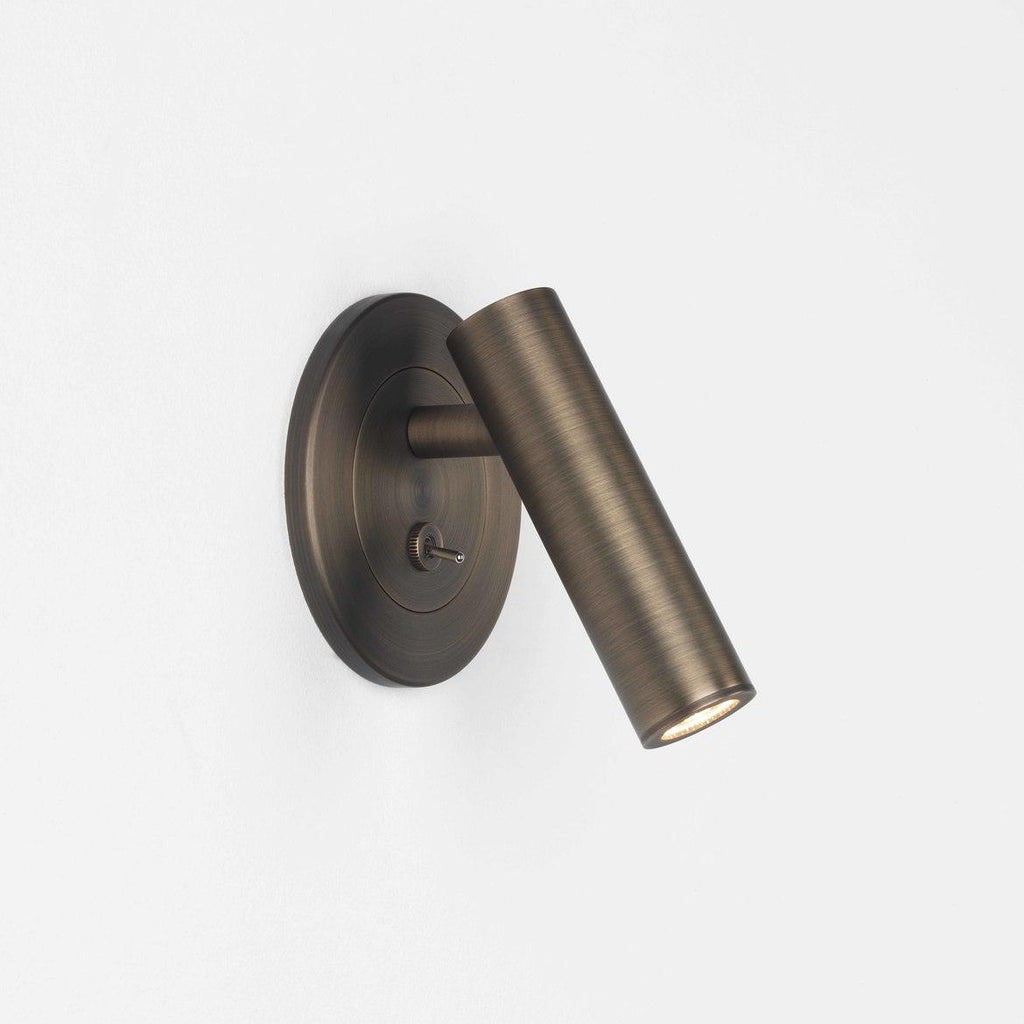 Pivoting L-shaped wall sconce arm angled for bedside reading