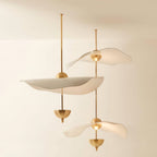 Envolee Double Biscuit gold and white pendant light glowing warmly over a living space