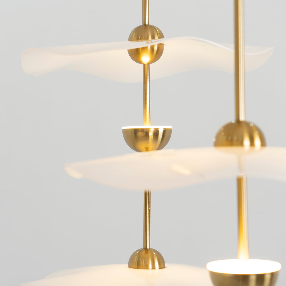 Close detail of the Envolee Double Biscuit pendant's layered white shade and gold frame