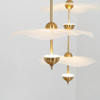 Envolee Double Biscuit gold and white pendant light glowing warmly over a living space