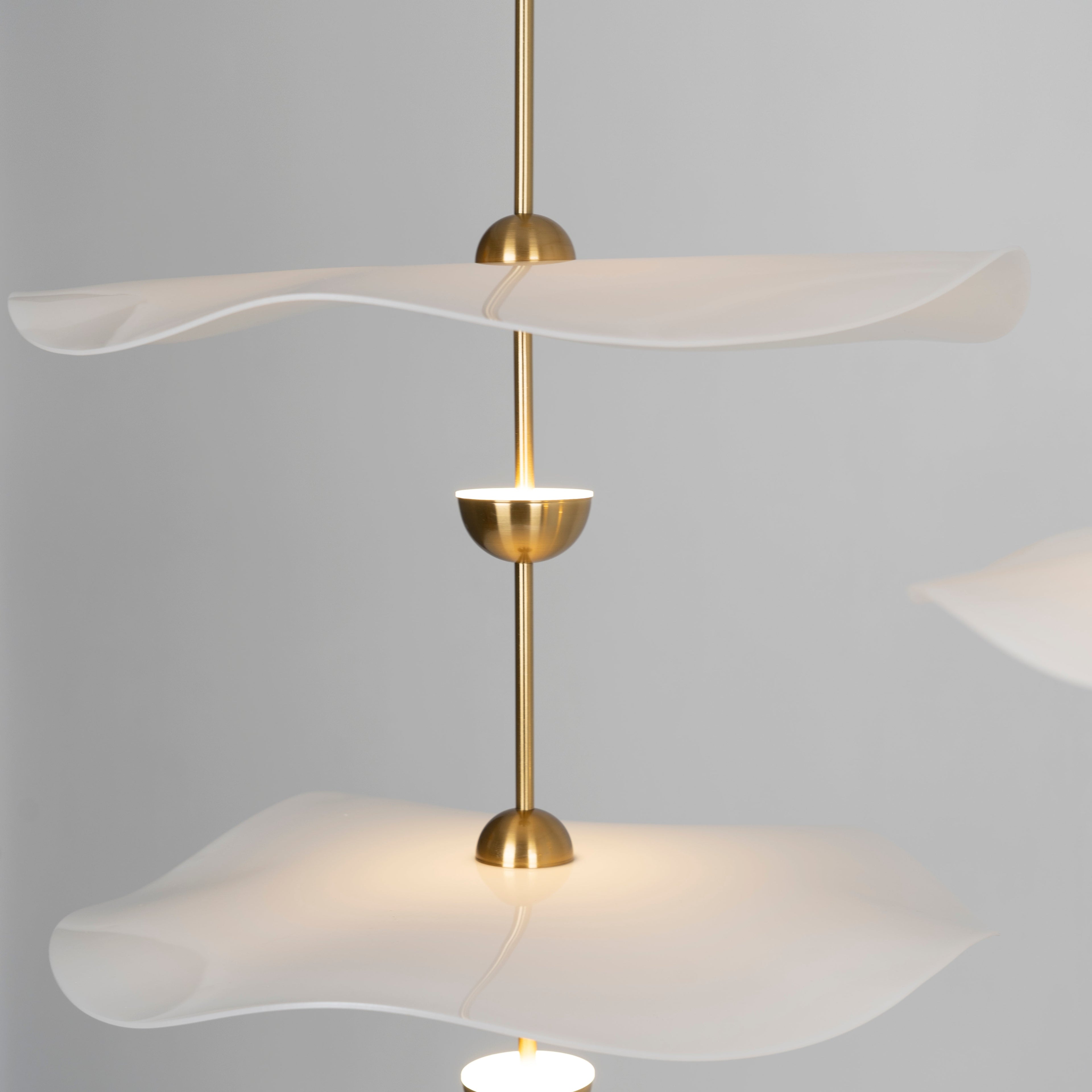 Envolee Double Biscuit gold-bodied pendant light suspended from an adjustable rod