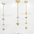 Envolee Double Biscuit pendant light in gold and white hanging above a styled dining table