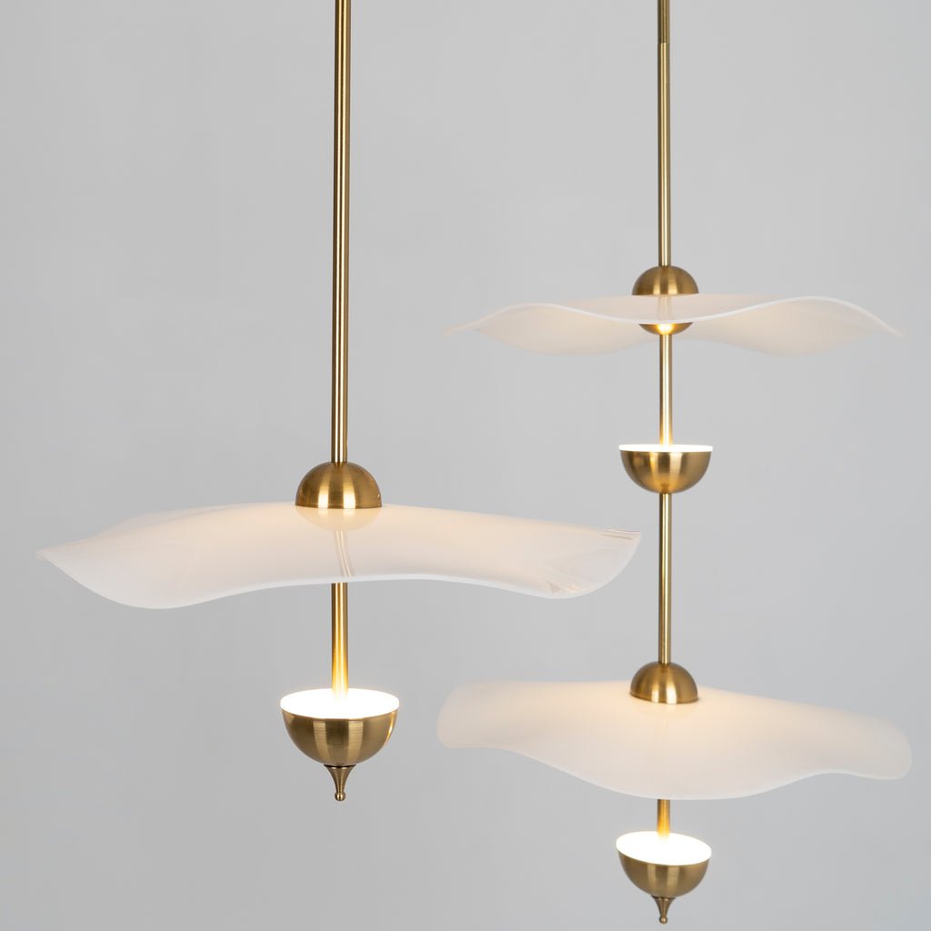 Envolee Double Biscuit pendant light in gold and white hanging above a styled dining table