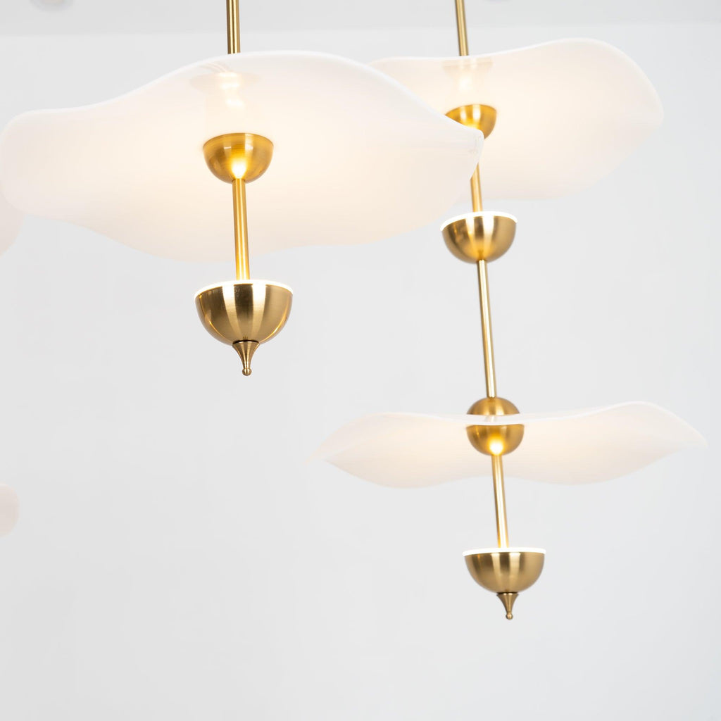 Envolee Double Biscuit gold and white pendant light glowing warmly over a living space