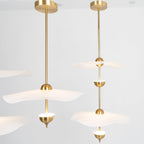 Envolee Double Biscuit gold and white pendant light glowing warmly over a living space