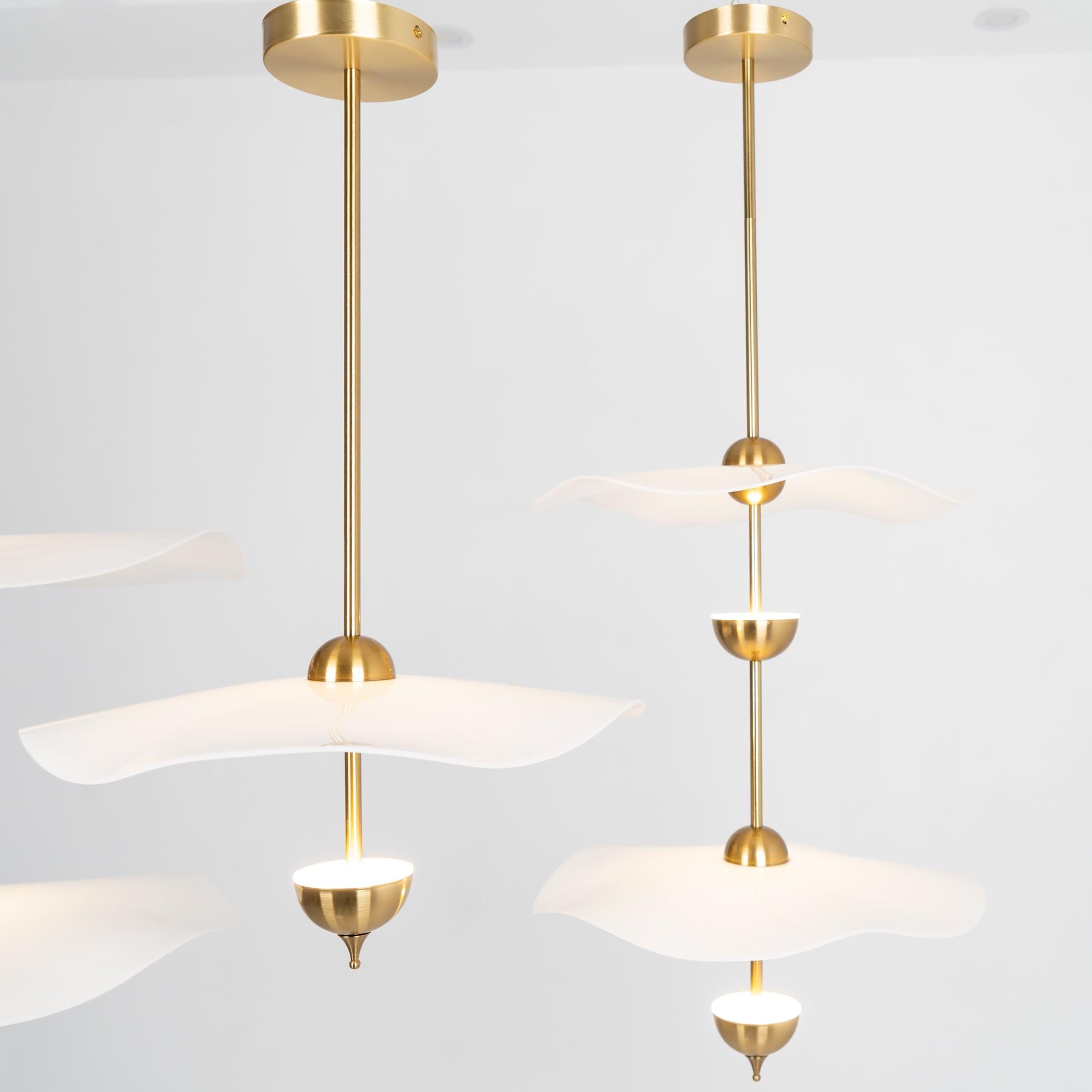 Close detail of the Envolee Double Biscuit pendant's layered white shade and gold frame