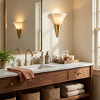 Reflected in the mirror above a walnut vanity with woven baskets, this Clérachic sconce glows in brushed brass by a window.