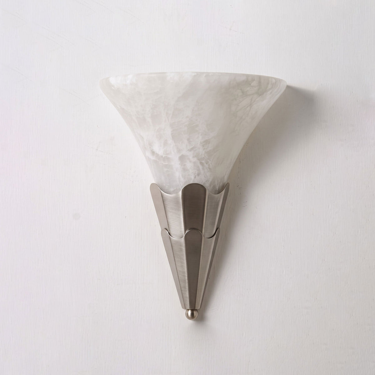 Studio shot on a bare backdrop, this Clérachic sconce's alabaster shade sits on a brushed nickel fluted base.