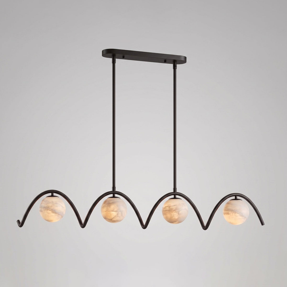 Against a plain grey backdrop, this Clérachic chandelier's four arched tubes and ball shades sit in matte black.
