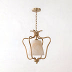 Cropped close on a plain background, this Clérachic pendant's brass cage curls around the base of its alabaster shade.
