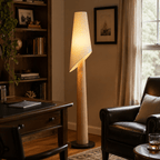 This Clérachic floor lamp glows in a home office corner, beside a leather armchair and a dark wood desk.