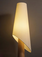 Close-up of the Clérachic floor lamp's angled fabric shade meeting its tapered wood-toned body.