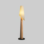 A lighter wood-toned Clérachic floor lamp stands lit against a plain grey studio background.