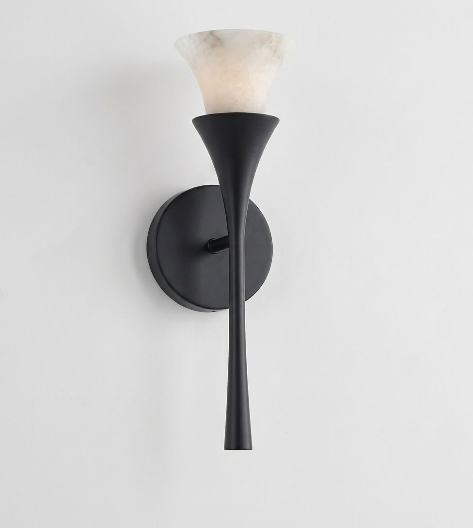 Lit against a plain white background, this Clérachic sconce's alabaster shade glows atop a matte black trumpet stem.