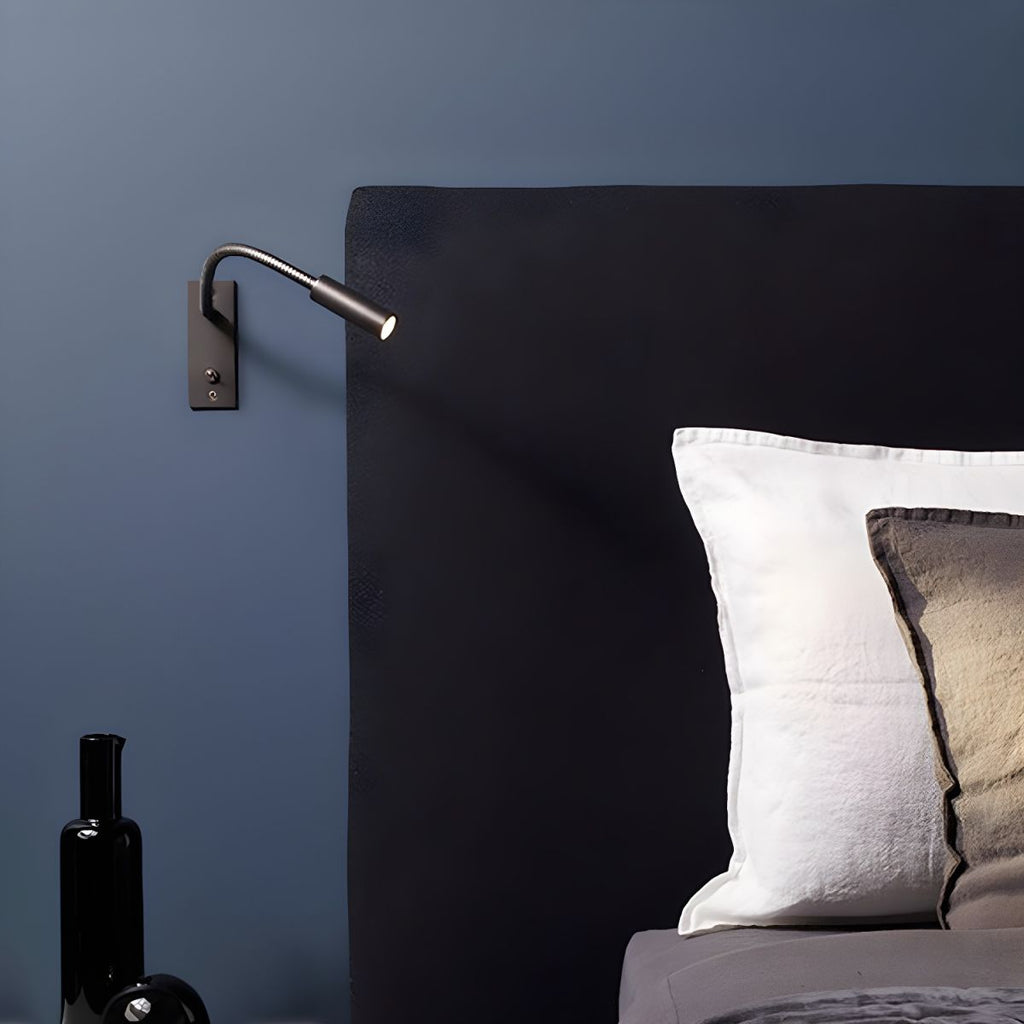 Gooseneck wall lamp directing a warm focused beam onto a surface