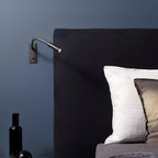 Gooseneck wall lamp directing a warm focused beam onto a surface