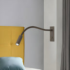 Brushed bronze gooseneck wall lamp aimed for bedside reading