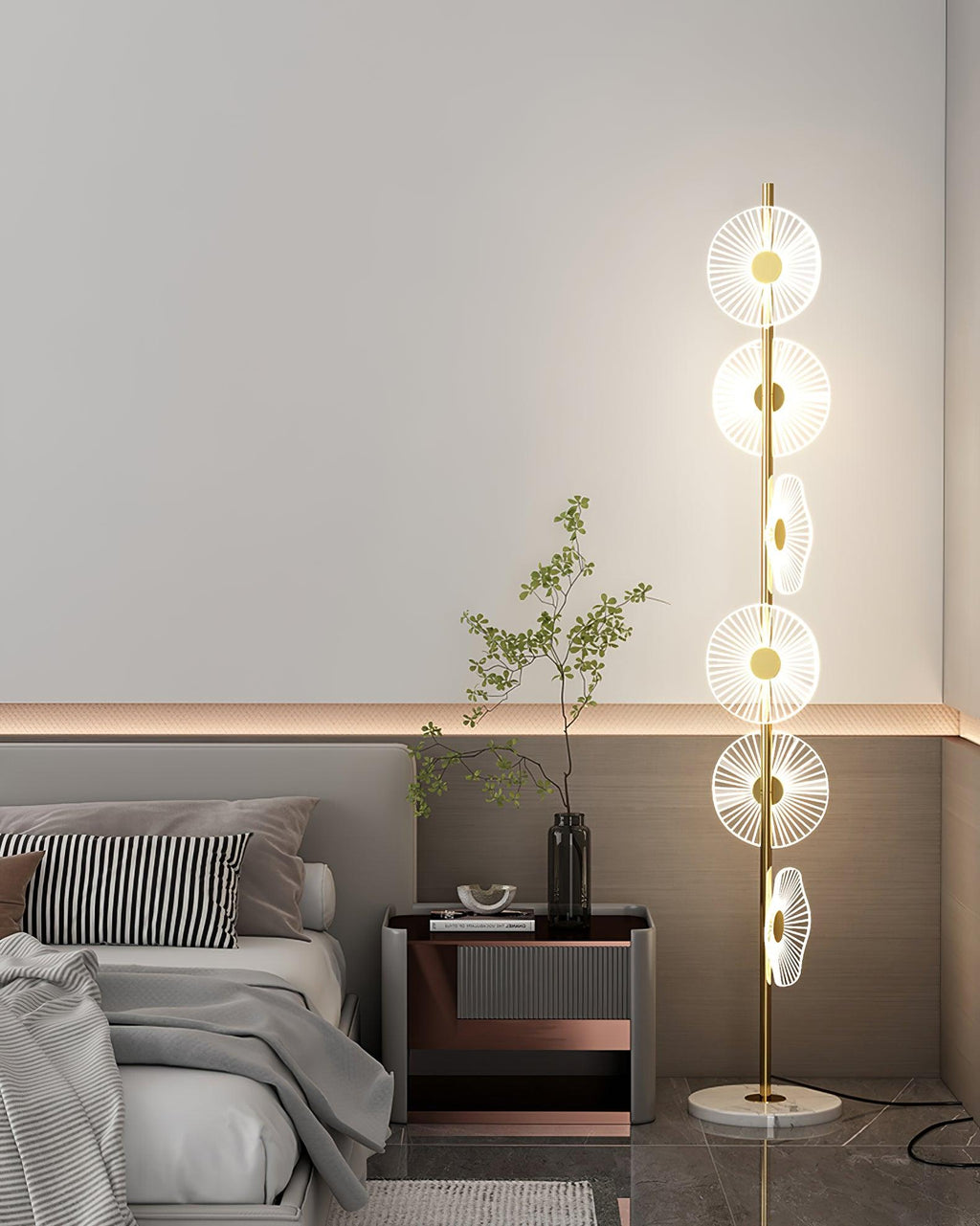 Near a striped cushion and a copper-trimmed nightstand holding a sprig of leaves, this Clérachic floor lamp lights the corner.