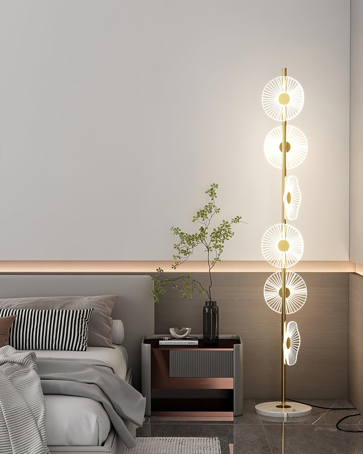Near a striped cushion and a copper-trimmed nightstand holding a sprig of leaves, this Clérachic floor lamp lights the corner.