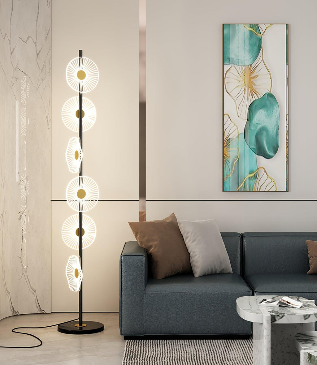 Against a marble-textured wall and a dark teal sofa, this Clérachic floor lamp stands on a black round base.