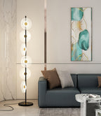 Against a marble-textured wall and a dark teal sofa, this Clérachic floor lamp stands on a black round base.