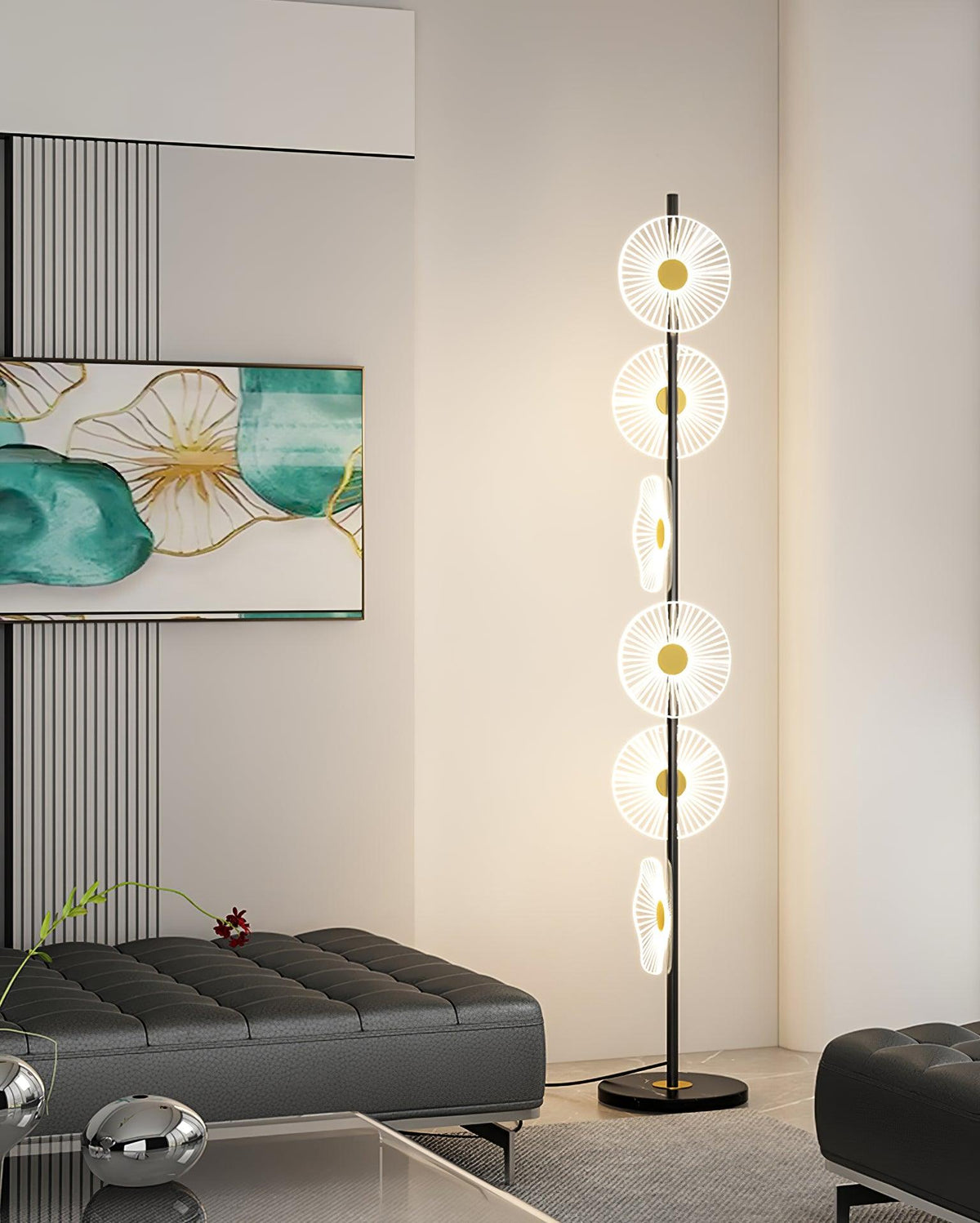 Near a dark tufted ottoman and small chrome ball ornaments, this Clérachic floor lamp's lit discs rise beside a teal print.