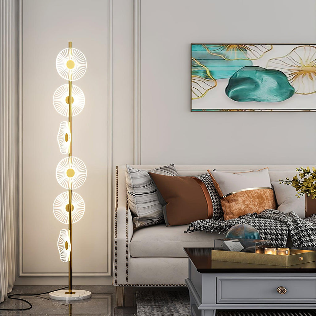 Lit beside a cream sofa and teal abstract print, this Clérachic floor lamp's tiered acrylic discs rise from a round marble base.