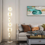 Lit beside a cream sofa and teal abstract print, this Clérachic floor lamp's tiered acrylic discs rise from a round marble base.