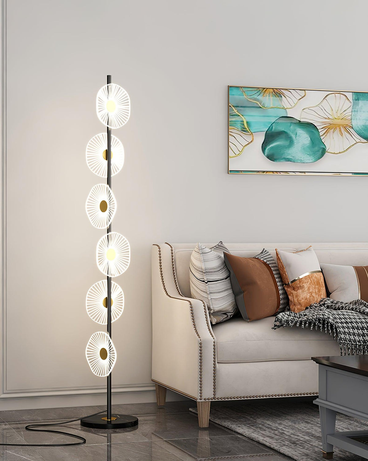 This Clérachic floor lamp stands on a dark round base beside a tufted sofa, its stacked acrylic discs glowing up the gold pole.