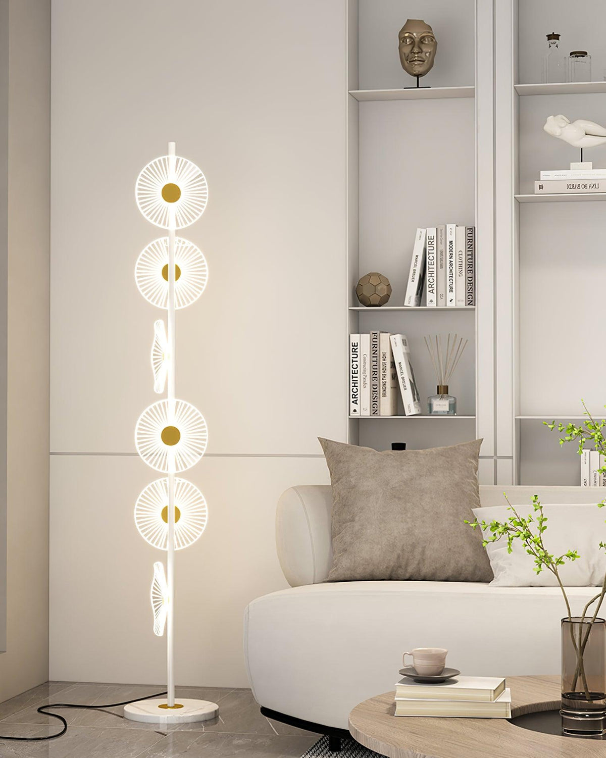 Beside a grey tufted sofa and a shelf of small sculptures, this Clérachic floor lamp's warm discs light the corner of the room.