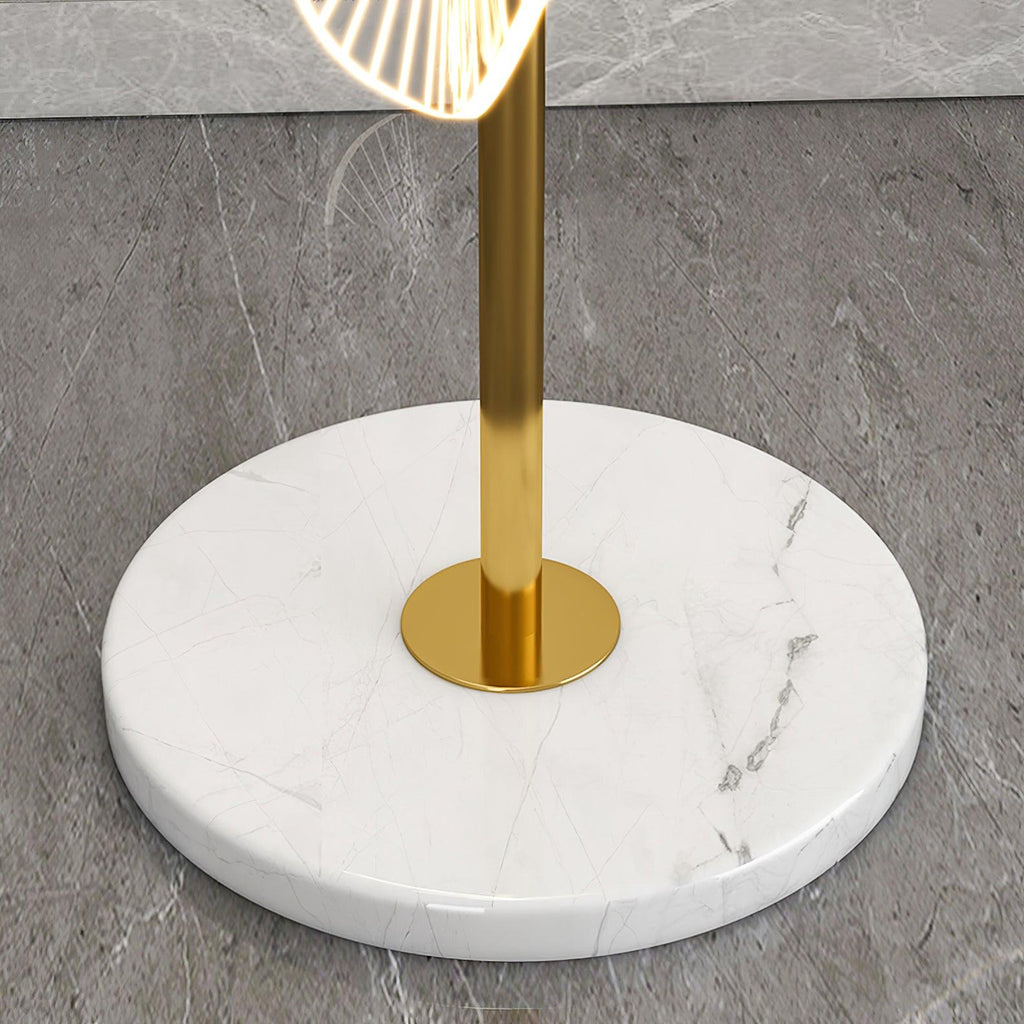 A macro detail shows this Clérachic floor lamp's gold pole meeting its round white marble base, veined in soft grey.