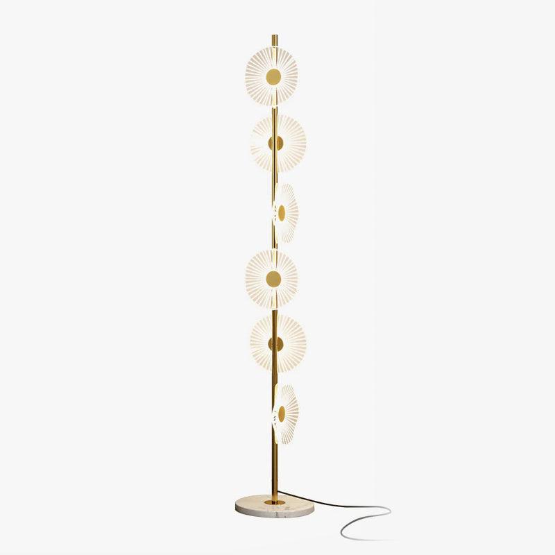 Tiered brass discs cascade like falling raindrops down a slender pole rising from a round marble base, shown studio-lit for this Clérachic floor lamp.
