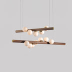 Row of opal glass globes glowing beneath a walnut wood bar