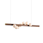 Horizontal walnut pendant light above a styled dining setting