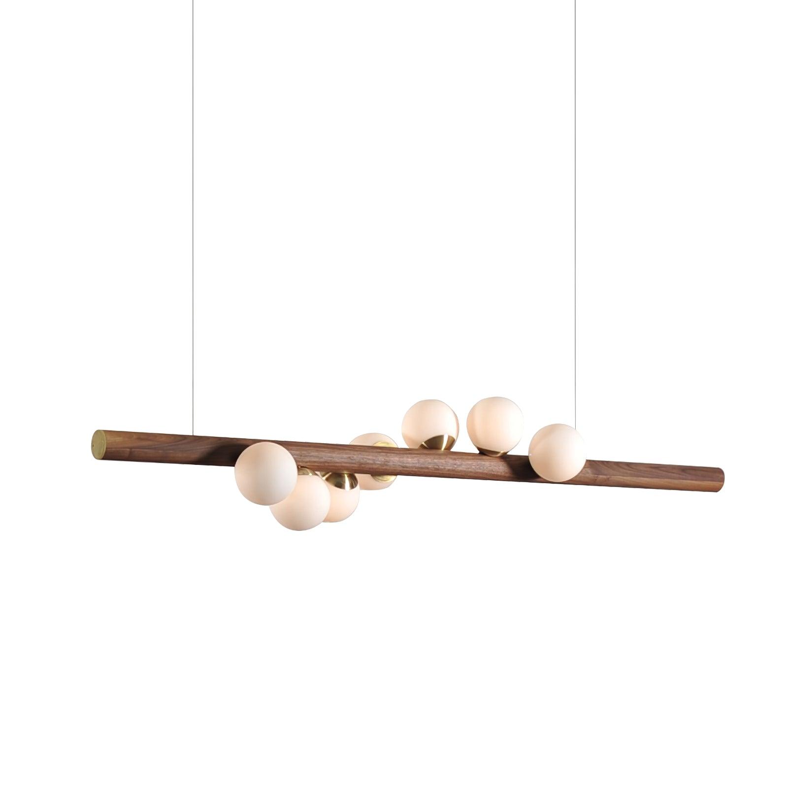 Horizontal walnut pendant light above a styled dining setting