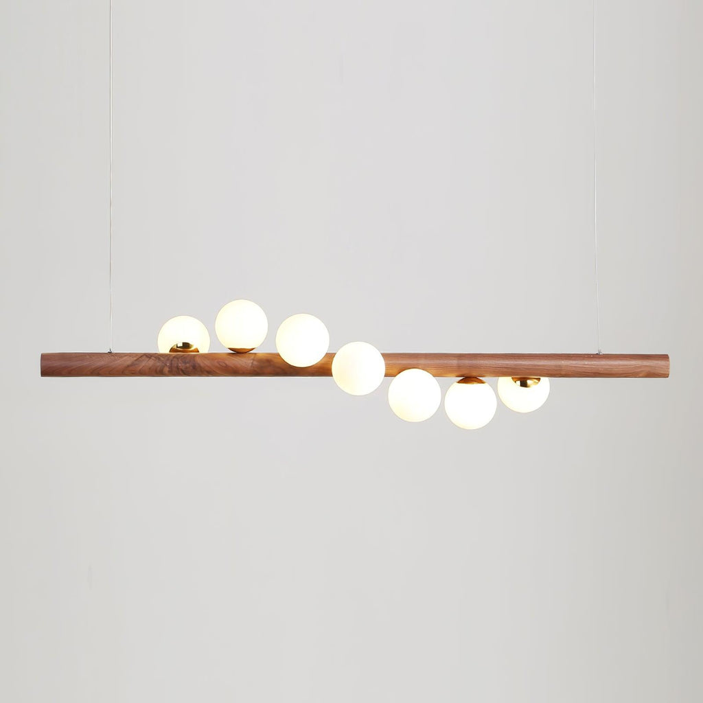 Walnut pendant light glowing above a dining table at night